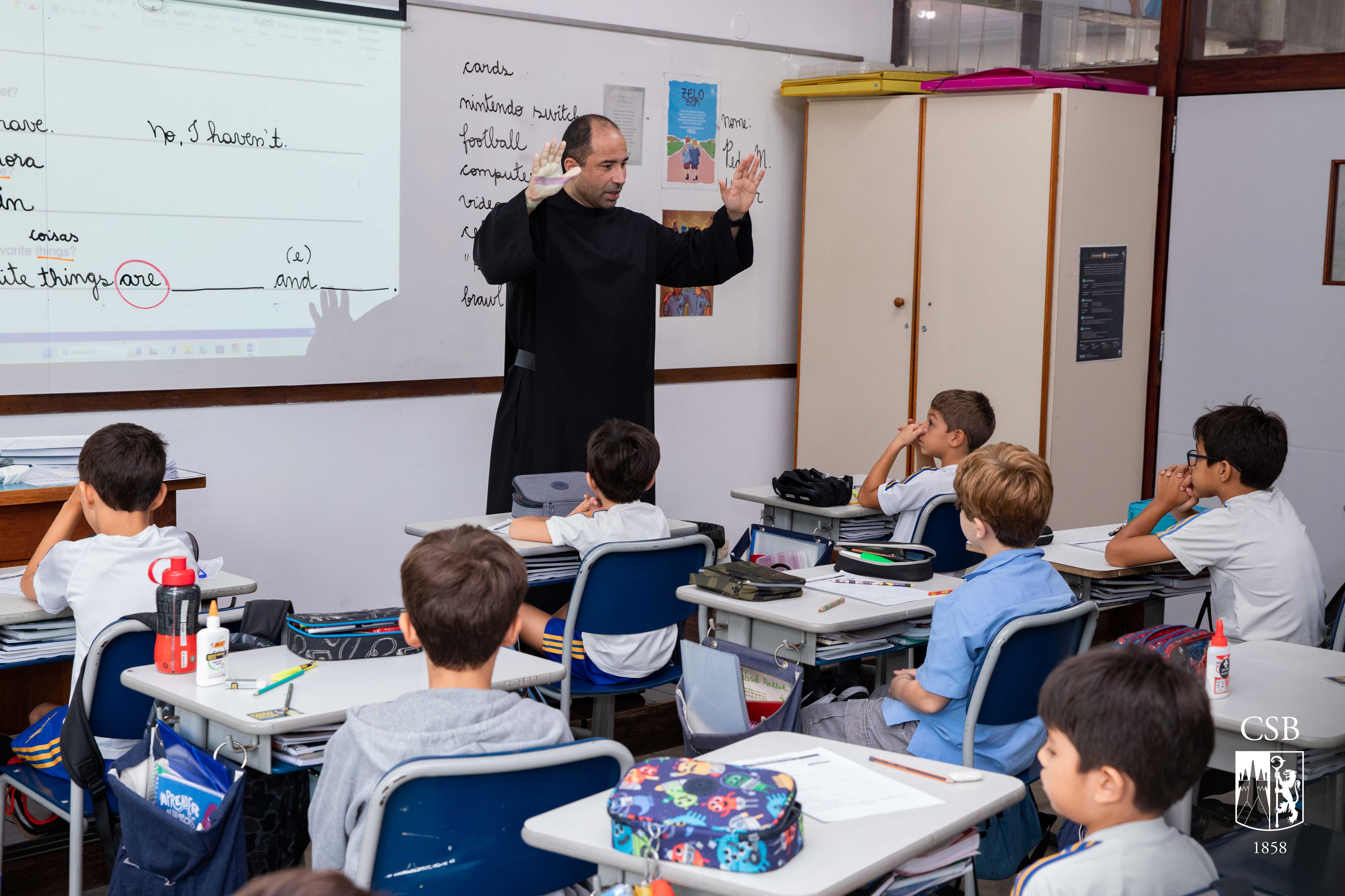 Monges beneditinos abençoam alunos em sala de aula